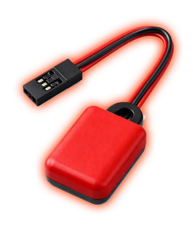 Small rugged orange racing transponder device on concrete surface