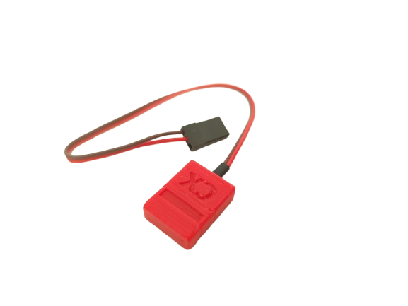 Small rugged orange racing transponder device on concrete surface